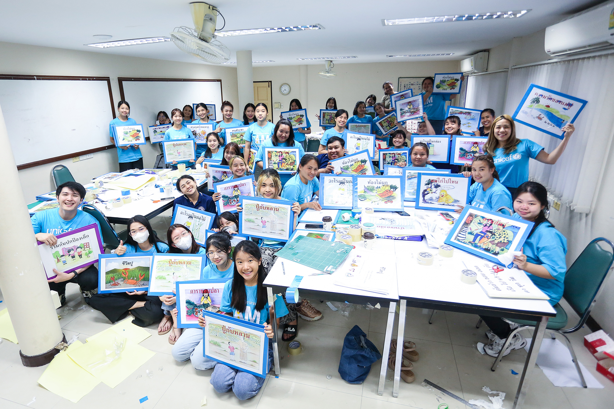children in class holding up colorful storybooks